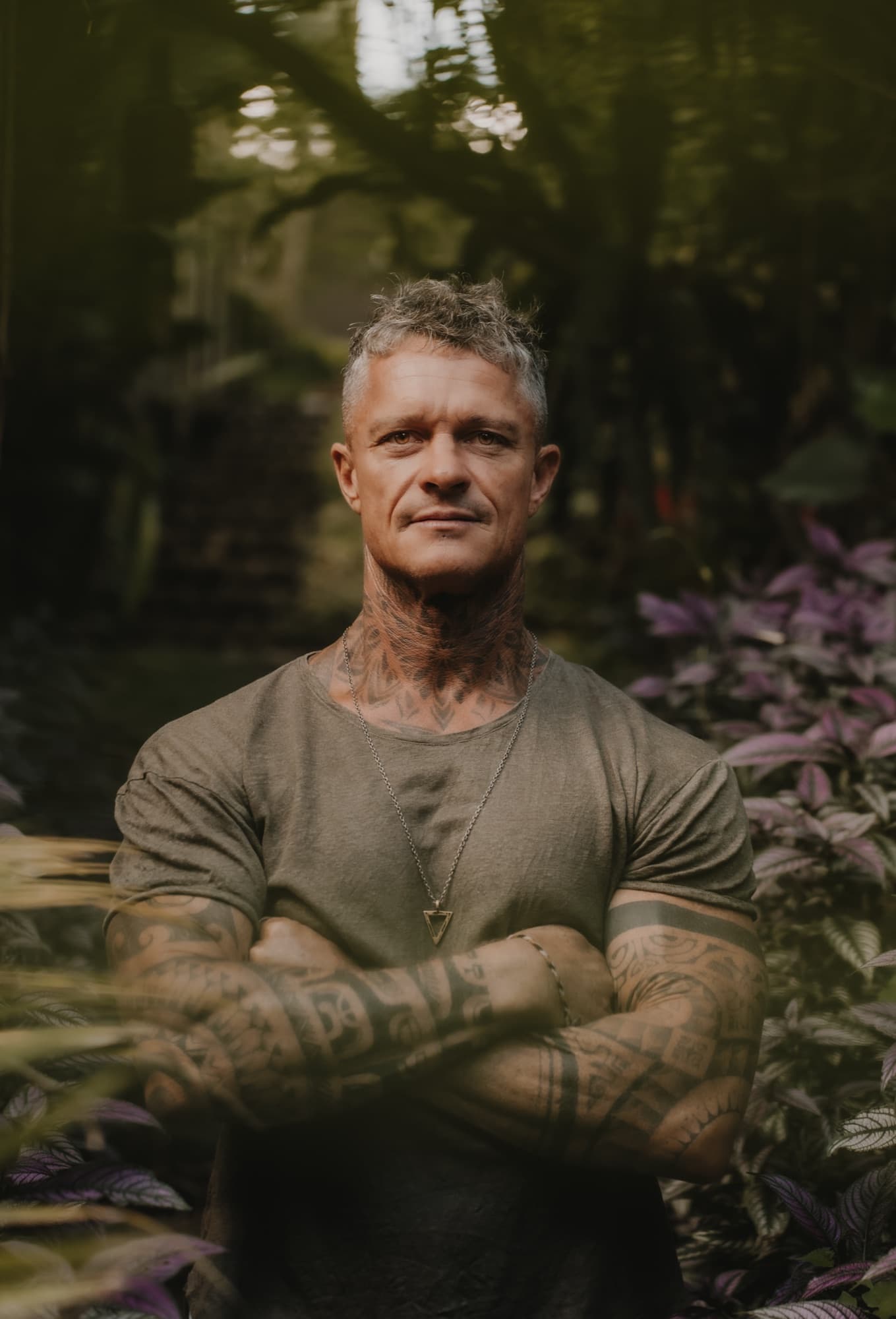 Mikkail Handby standing in the garden, arms folded